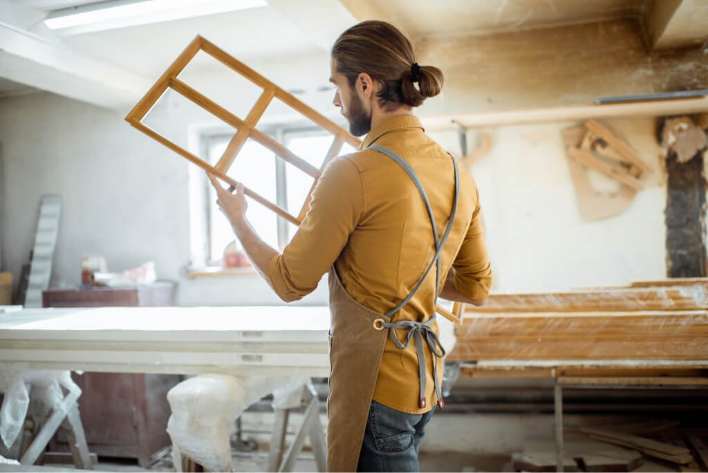 carpenter with window frame at the workshop